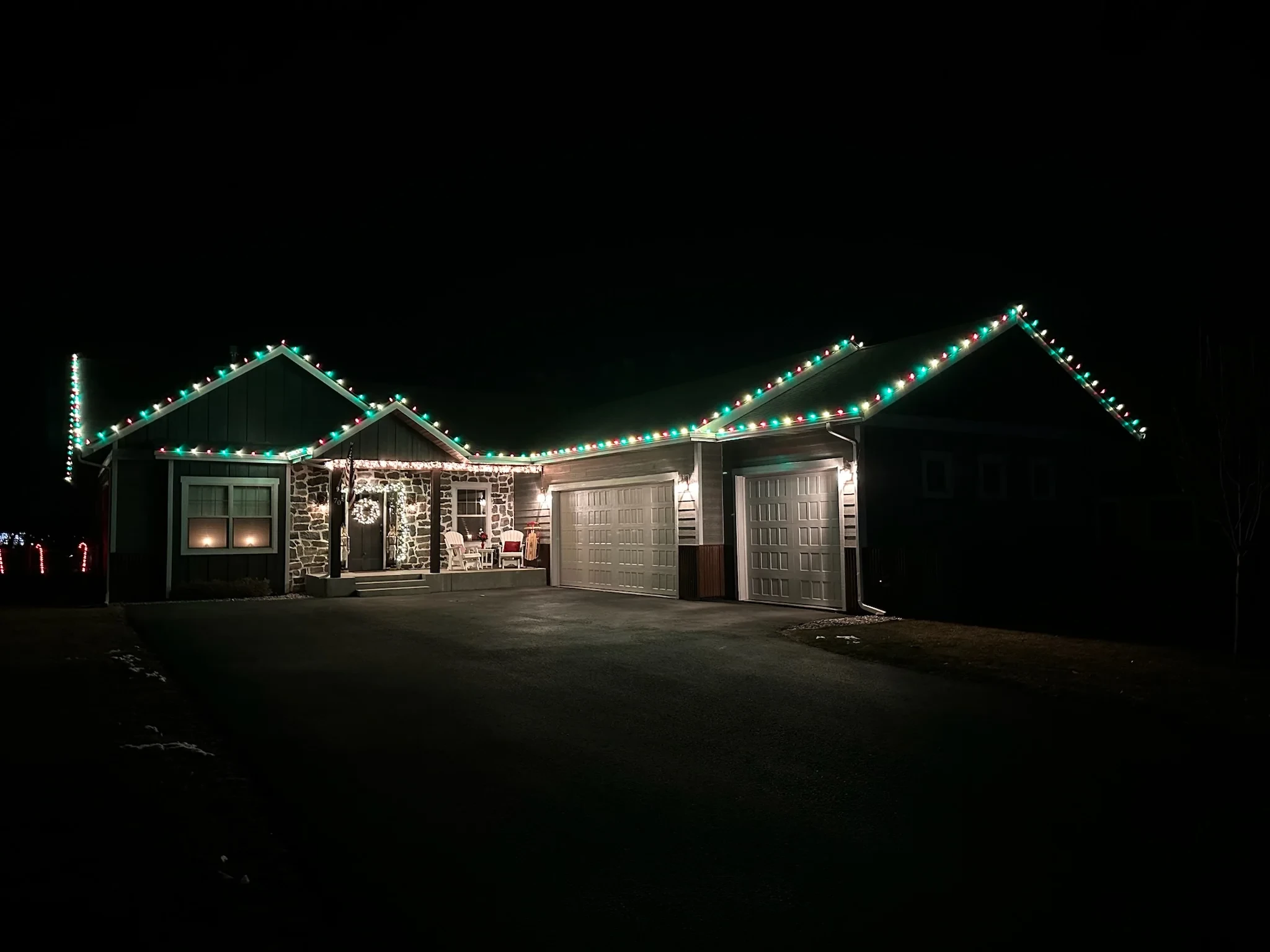 Single-story home with alternating red, green and warm white roofline lights.